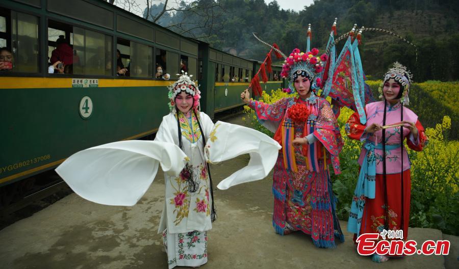 Tourists don traditional costumes to pose for a photo with the Jiayang steam train in Jianwei County, Southwest China’s Sichuan Province, March 12, 2019. The Jiayang steam train, which has been running for half a century and still operates on old narrow-gauge tracks, is a major contributor to the local tourism industry. (Photo: China News Service/Liu Zhongjun)
