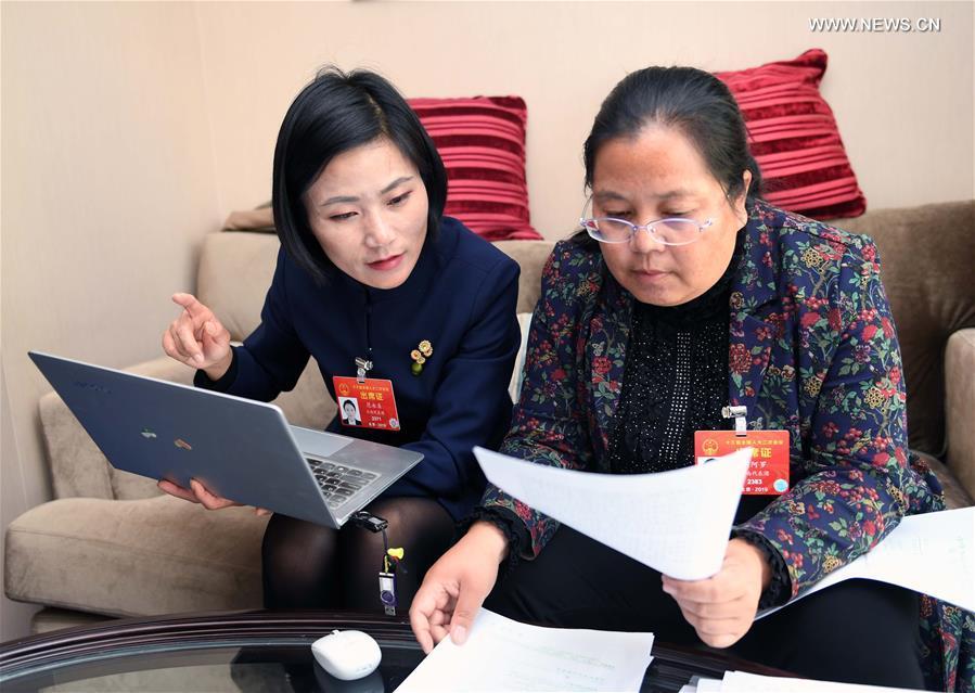 Fan Yongzhen (L), a deputy to the 13th National People\'s Congress (NPC), discusses with her fellow deputy Hu Aluo in Beijing, capital of China, March 6, 2019. (Xinhua/Yang Zongyou)
