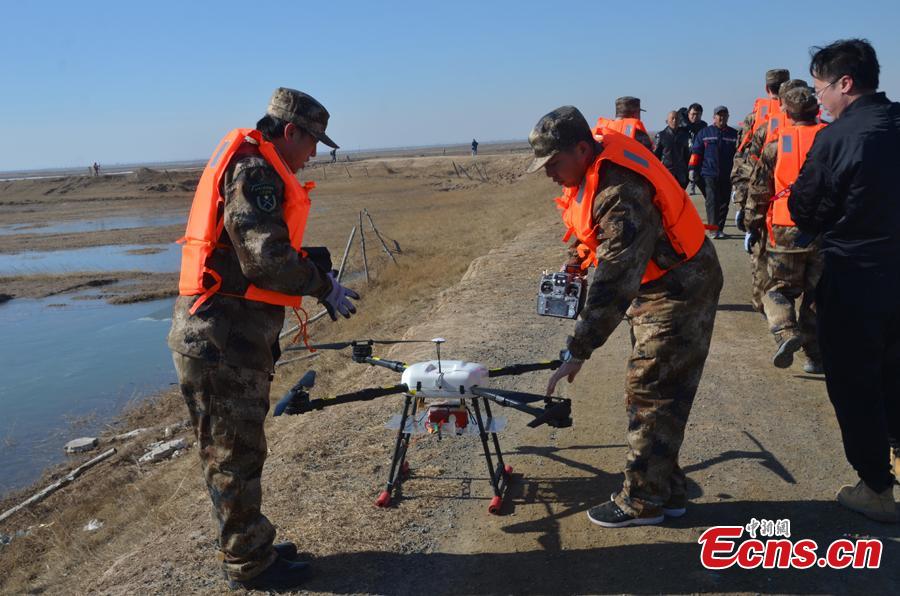 A drill is held to practice ice-clearing methods to be used both in the Yellow River and on ground in Baotou City, North China\'s Inner Mongolia Autonomous Region, March 13, 2019. The region\'s Flood Control and Drought Relief Office deployed bomber, hovercraft and drone in the drill. (Photo: China News Service/Zhang Linhu)