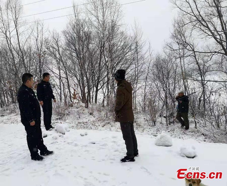 Police officers investigate a suspected Siberian tiger attack on a dog in a mountain village close to the Russian border in Hegang City, Northwest China’s Heilongjiang Province. Local police are urging villagers to be alert to possible tiger attacks. (Photo provided to China News Service)