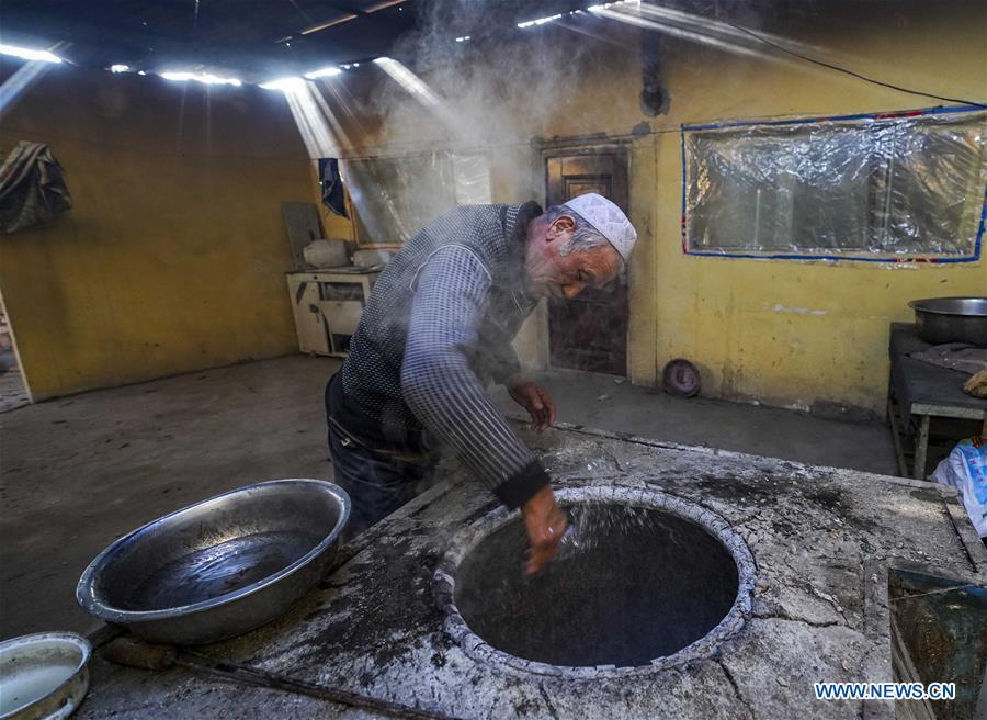A baker sprays salty water into an oven before baking \