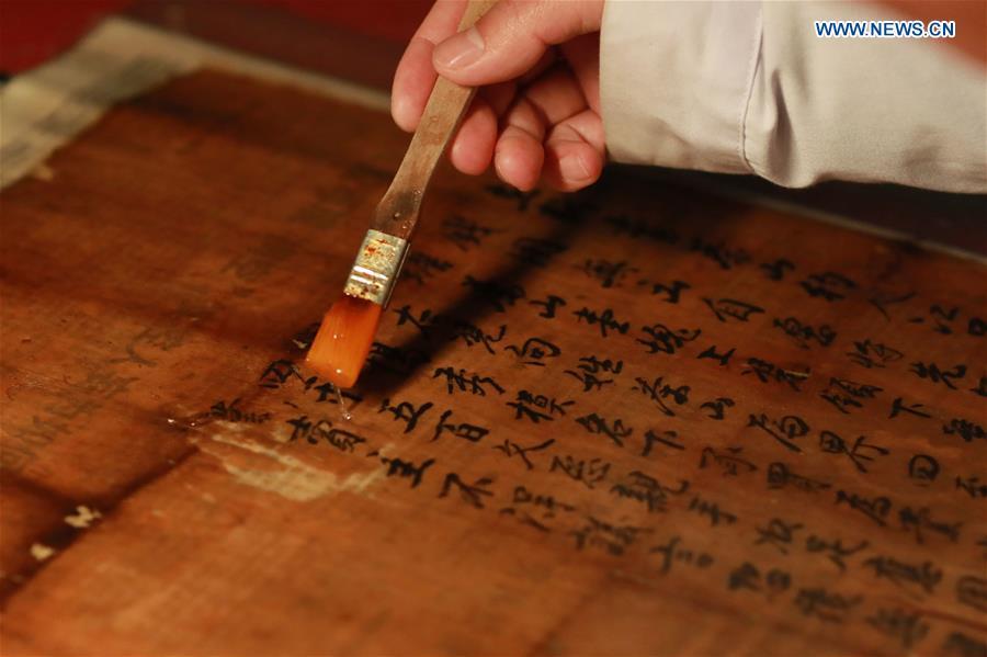 A staff member of a museum of Jinping Writs, conducts paper-pasting on a document at the museum in Jinping County, southwest China\'s Guizhou Province, March 18, 2019. Dating back to the Ming Dynasty (1368-1644), \