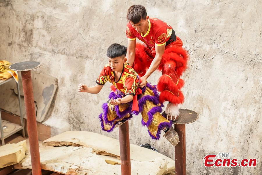 <?php echo strip_tags(addslashes(Tang Yifeng (L), a sixth grader, learns about lion dance in Tengxian County, Wuzhou City, South China's Guangxi Zhuang Autonomous Region, March 18, 2019. Tengxian is home to a special folk lion dance. The dance troupe, which formed in 1997, has won many top awards in contests, and its unique stunts that imitate a drunken lion or a lion climbing a cliff, for example, are particularly mind-blowing. (Photo: China News Service/Chen Guanyan))) ?>