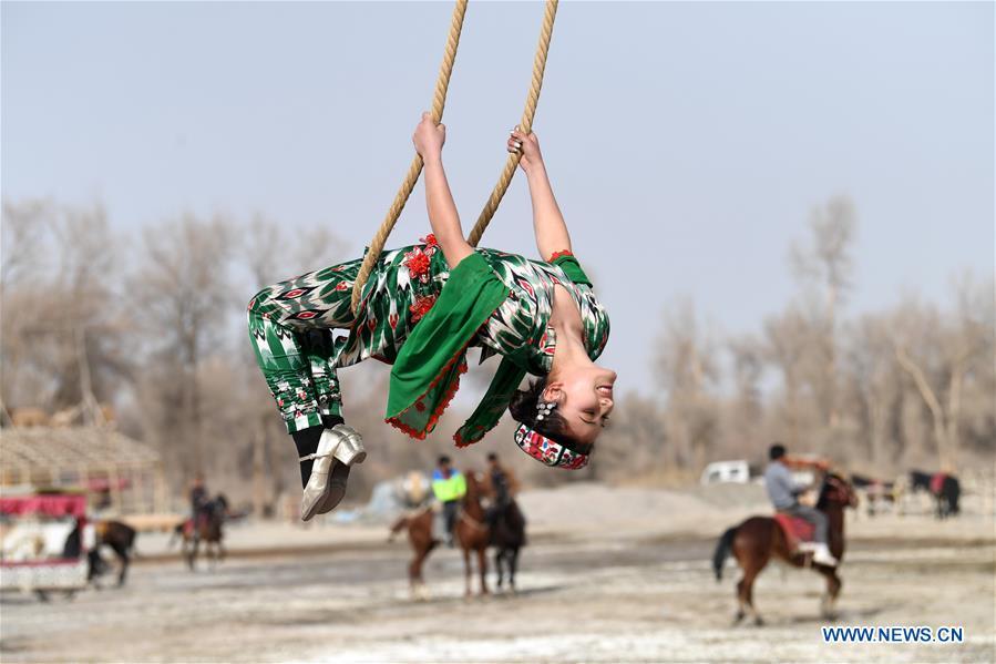 A girl participates in Shaghydi game in Daolang scenic spot of Awat County, northwest China\'s Xinjiang Uygur Autonomous Region, on March 12, 2019. Shaghydi is an ethnic sport game of Uygur people. Players push the bearings around to help people swing on ropes. (Xinhua/Sadat)