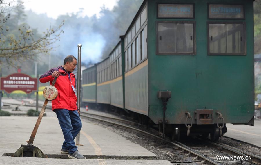 A train dispatcher works at a station where a Jiayang steam train stops in Qianwei County, southwest China\'s Sichuan Province, March 20, 2019. The old-fashioned steam train, running on a narrow gauge railway in Qianwei County, serves mainly in sightseeing, but as increasing number of tourists visit the county in recent years, the train itself has become an attraction providing a journey of reminiscence. (Xinhua/Jiang Hongjing)