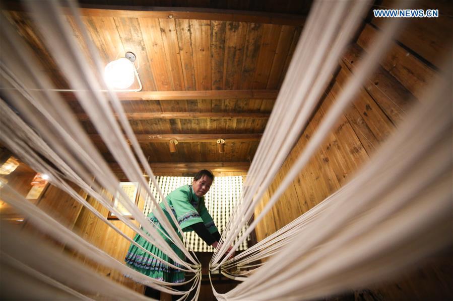 A woman of Dong ethnic group prepares to weave cloth at Laozhai Village of Yuping Dong Autonomous county of Tongren, southwest China\'s Guizhou Province, March 23, 2019. Traditional Dong cloth making has a long history. The procedure includes planting cotton, spinning, weaving, dyeing, etc. And the cloth enjoys lasting popularity among the people of Dong ethnic group. (Xinhua/Luo Dafu)