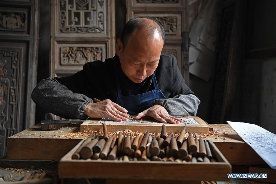 Yu Youhong makes carvings on wood at his studio in Wangkou Village, Wuyuan County of east China\'s Jiangxi Province, March 18, 2019. The \