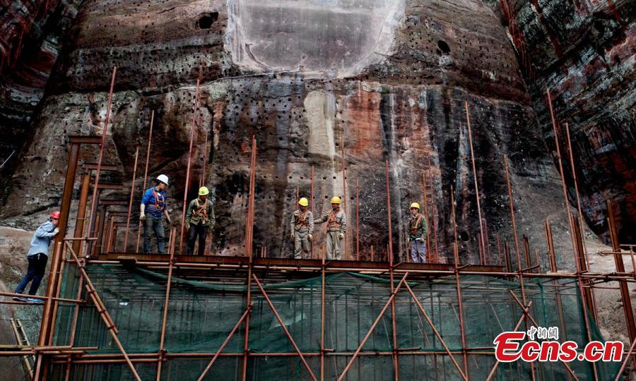 Work continues to restore the Giant Buddha of Leshan in Sichuan Province, March 25, 2019. Standing 71 meters high, the statue was carved out of a hillside in the 8th century and looks down on the confluence of three rivers. It will reopen to tourists on April 1 after undergoing repairs for the past six months. Mount Emei Scenic Area, including the Leshan Giant Buddha, was inscribed as a UNESCO world heritage site in 1996. (Photo: China News Service/Liu Zhongjun)