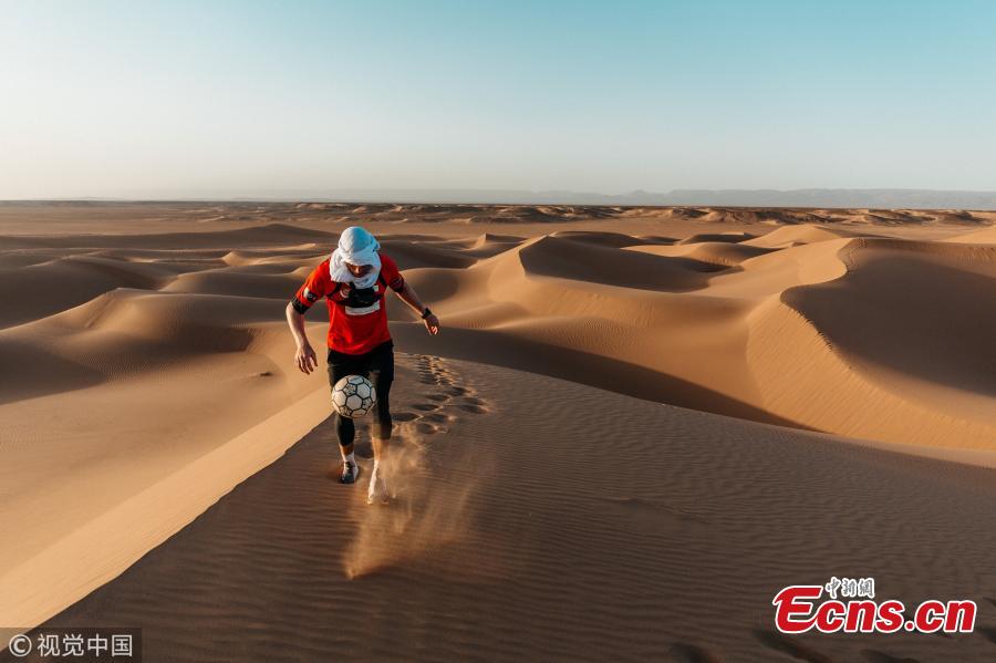 Freestyle footballer John Farnworth battled a sandstorm and 40C heat to play \'keepie-uppies\' across 60 miles of the Sahara. He juggled a ball in the air more than 250,000 times over the course of six days across the African desert in a bid to break his ninth world record. Farnworth worn goggles and specially designed trainers to keep sand out during the storm. Joined by three friends, he enlisted the help of four Moroccans to help navigate across the sprawling landscape. (Photo/VCG)