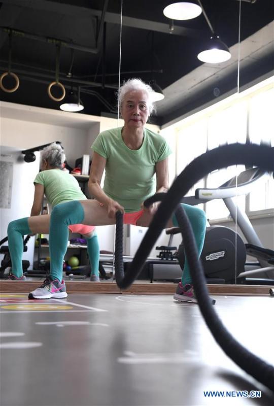 Bai Jinqin, a 74-year-old bodybuilding adept, exercises at a gym in north China\'s Tianjin, March 13, 2019. Bai has kept exercising for 14 years. After finishing her housework, Bai likes to spend one hour every day at the gym to build her body. The hobby has rewarded her with good physique and energy. (Xinhua/Yue Yuewei)