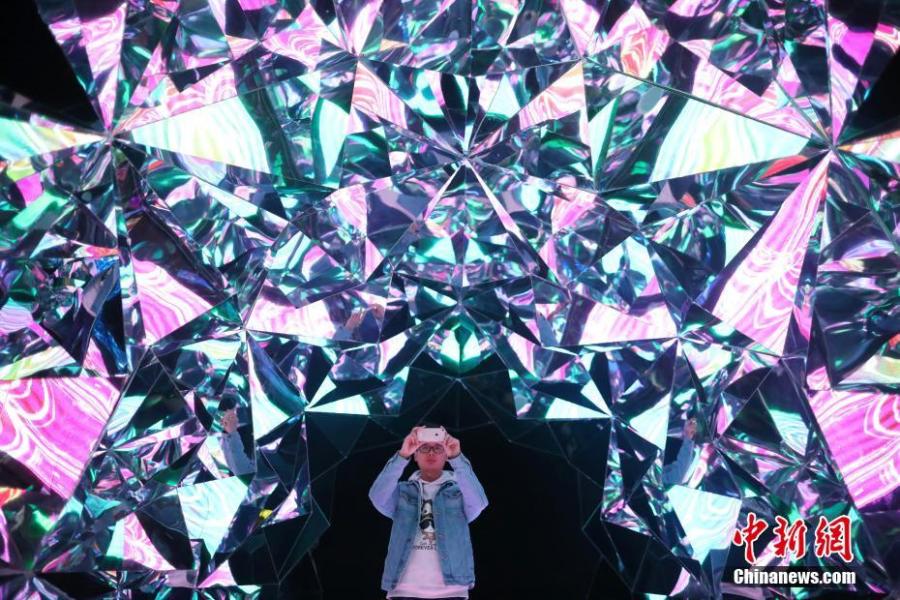 A visitor takes photos at the exhibition Traversing Through Fantasy held in Changzhou, East China\'s Jiangsu province, March 27, 2019.