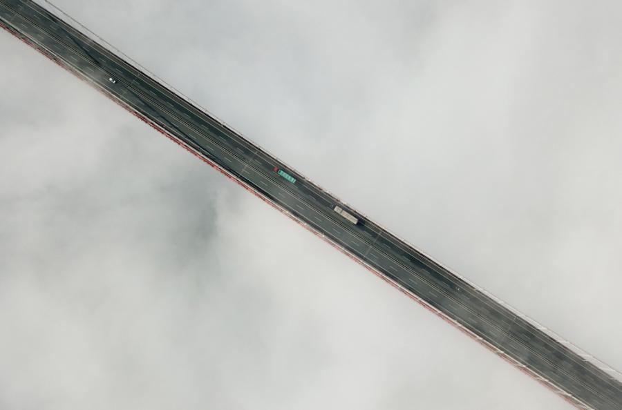 An aerial photo shows vehicles moving on the cloudy Aizhai Bridge, a suspension bridge on the Baotou-Maoming Expressway in Jishou city, Hunan Province. (Photo/chinadaily.com.cn)