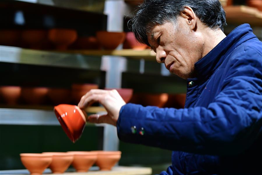 <?php echo strip_tags(addslashes(Wu Lizhu, inheritor of the workmanship of Jianzhan teaware, glazes a piece of porcelain at his workshop in Jianyang District of Nanping City, south China's Fujian Province, March 28, 2019. Jianzhan teaware, a well-known Chinese porcelain originated in Jianyang, dates back to more than 1,000 years ago in Song dynasty (960-1279). It was the best teaware for scholars and literati to use during that time in tea competitions. Jianzhan teawares are known for their variability. Glazes can range in color from dark plum to yellow, green, and blue. During the heating and cooling processes, iron element in the clay can migrate within the glaze to form surface crystals in rich and glossy colors, as in the 