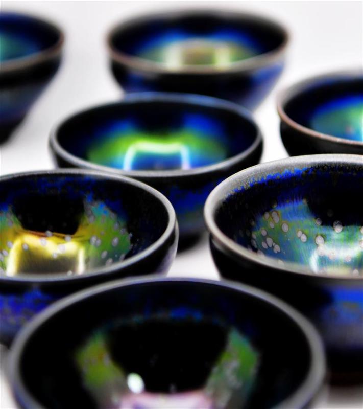 Photo taken on March 28, 2019 shows pieces of porcelain made by Wu Lizhu, inheritor of the workmanship of Jianzhan teaware, at his workshop in Jianyang District of Nanping City, south China\'s Fujian Province. Jianzhan teaware, a well-known Chinese porcelain originated in Jianyang, dates back to more than 1,000 years ago in Song dynasty (960-1279). It was the best teaware for scholars and literati to use during that time in tea competitions. Jianzhan teawares are known for their variability. Glazes can range in color from dark plum to yellow, green, and blue. During the heating and cooling processes, iron element in the clay can migrate within the glaze to form surface crystals in rich and glossy colors, as in the \