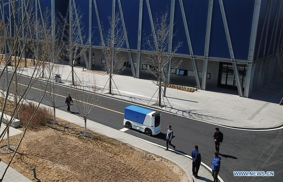 <?php echo strip_tags(addslashes(Aerial photo taken on March 31, 2019 shows an unmanned express delivery vehicle running on the street of Xiongan citizen service center in Xiongan New Area, north China's Hebei Province. The unmanned express delivery vehicle, independently researched and developed by Cainiao Network, Alibaba's logistics arm, was recently put into service at Xiongan citizen service center. The new energy vehicle can convey about 200 small packages at one time from delivery station to intelligent cabinet. (Xinhua/Jin Liangkuai))) ?>