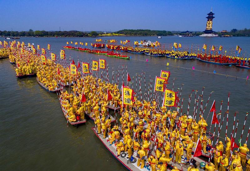 People participate in a boat performance during the 2019 Qintong Boat Festival held at Qinhu National Wetland Park in Jiangyan District of Taizhou, East China\'s Jiangsu province, April 6, 2019. Hundreds of boats with more than 10,000 boat team members aboard gathered here on Saturday for the Qintong Boat Festival, which has been a centuries-old tradition.