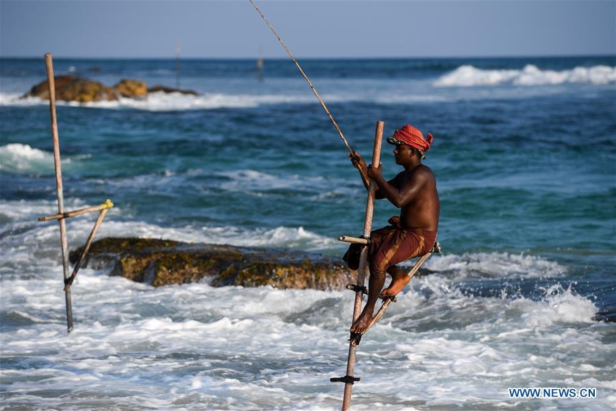 Stilt fishermen are silhouetted at a beach in Galle, Sri Lanka, April 7, 2019. Stilt fishing is a method of fishing unique to the island country of Sri Lanka. Local fishermen sit on a crossbar called \