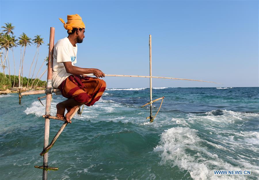 A stilt fisherman is seen at a beach in Galle, Sri Lanka, April 7, 2019. Stilt fishing is a method of fishing unique to the island country of Sri Lanka. Local fishermen sit on a crossbar called \