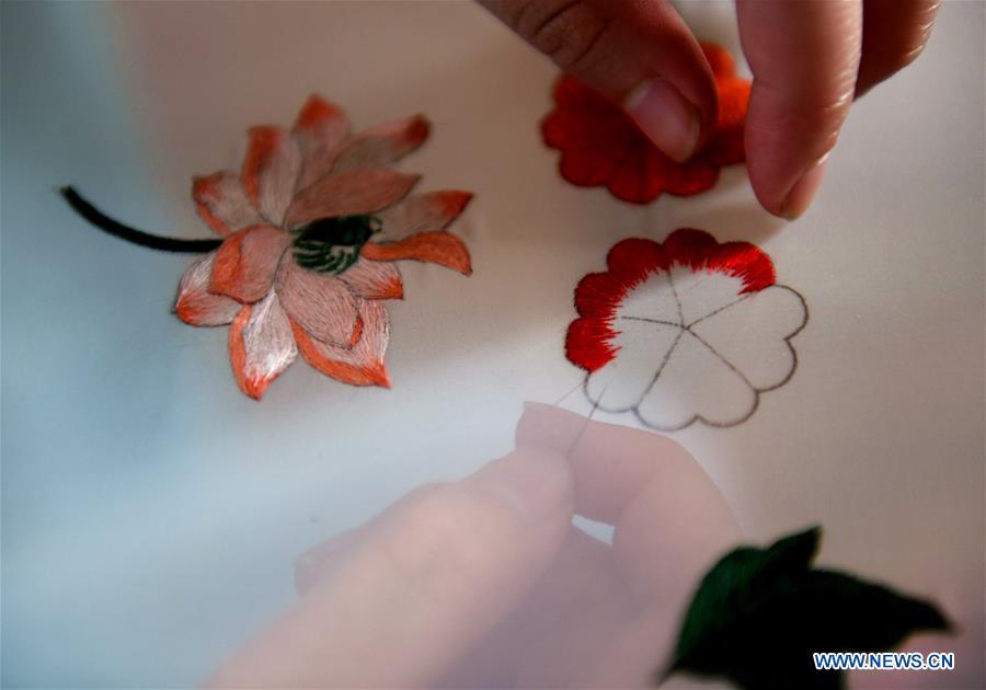 A trainee practices embroidery skills at craftswoman Liu Yuxia\'s studio in Qiaoxi District of Shijiazhuang, north China\'s Hebei Province, April 4, 2019. Liu Yuxia is an inheritor of Xu embroidery, which was listed as one of Shijiazhuang\'s intangible cultural heritages in 2018. Based on traditional Chinese embroidery skills, her works of unique style present the integration of Chinese and western painting techniques and photography. (Xinhua/Chen Qibao)