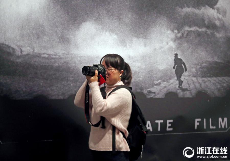 A visitor takes photos of photography works at an exhibition at the art museum of the China Academy of Art in Hangzhou, Zhejiang Province, on April 3. (Photo/zjol.com.cn)