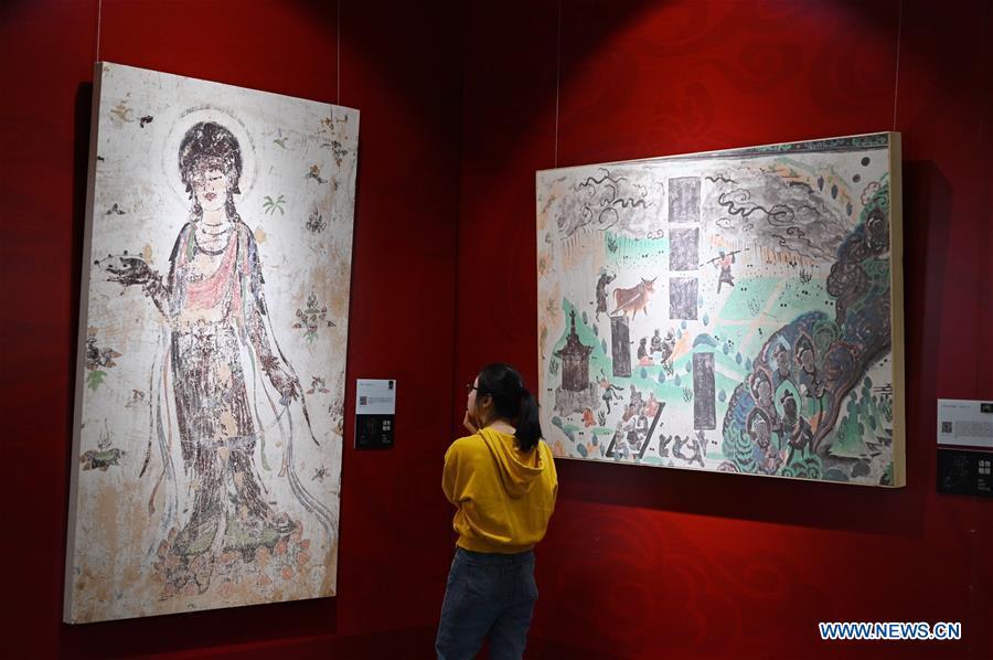 A visitor views frescoes during a Dunhuang fresco itinerant exhibition in Yunnan University in Kunming, southwest China\'s Yunnan Province, April 10, 2019. A Dunhuang fresco itinerant exhibition, with the participation of nearly 50 frescoes, was held in Yunnan University in Kunming Wednesday. (Xinhua/Qin Qing)