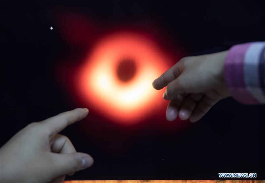 Chinese researchers discuss the imaging methods of the image of a black hole in Shanghai Astronomical Observatory (SAO), in east China\'s Shanghai, April 9, 2019. The image of the black hole, based on observations through the Event Horizon Telescope (EHT), a planet-scale array of eight ground-based radio telescopes forged through international collaboration, was unveiled in coordinated press conferences across the globe at around 9:00 p.m. (Beijing time) on Wednesday. The landmark result offers scientists a new way to study the most extreme objects in the universe predicted by Albert Einstein\'s general relativity. (Xinhua/Jin Liwang)
