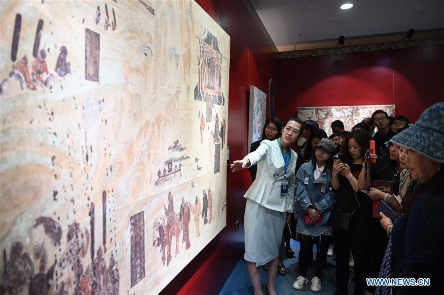 <?php echo strip_tags(addslashes(Ma Lin(L), a guide from Dunhuang Academy China, explains fresco culture to visitors during a Dunhuang fresco itinerant exhibition in Yunnan University in Kunming, southwest China's Yunnan Province, April 10, 2019. A Dunhuang fresco itinerant exhibition, with the participation of nearly 50 frescoes, was held in Yunnan University in Kunming Wednesday. (Xinhua/Qin Qing))) ?>