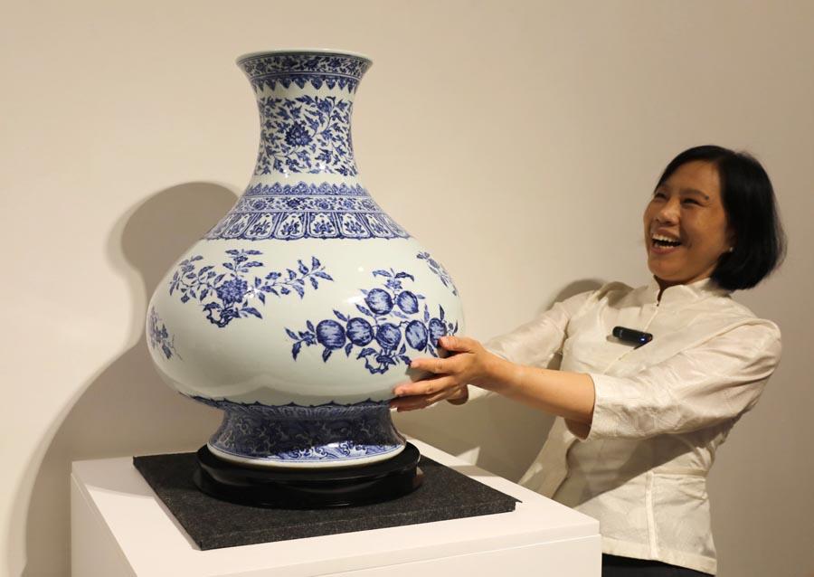 A staff member introduces a Qing Dynasty porcelain vessel created during the reign of Emperor Yongzheng at a media preview of Christie\'s Hong Kong Spring Auctions, April 11, 2019. (Photo/Xinhua)