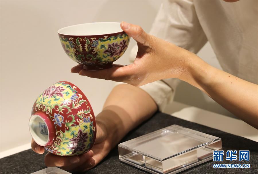 A staff member of auction house Christie\'s shows a pair of Qing Dynasty (1644-1911) porcelain bowls created during the reign of Emperor Yongzheng (1678-1735), at a media preview on April 11, 2019. The Christie\'s Hong Kong Spring Auctions 2019 will be held in Hong Kong from May 24 to 29. Those to go under the hammer include several treasured porcelain and handcraft works from ancient China, each estimated at more than HK$10 million ($1.2 million). (Photo/Xinhua)