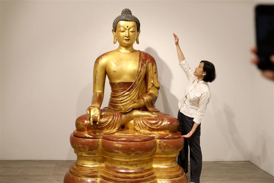 A staff member introduces a Qing Dynasty Buddha statue at a media preview of Christie\'s Hong Kong Spring Auctions, April 11, 2019. The estimated price of the 1.72-meter-tall statue is HK$30 million to HK$50 million ($4-$6 million).  (Photo/Xinhua)