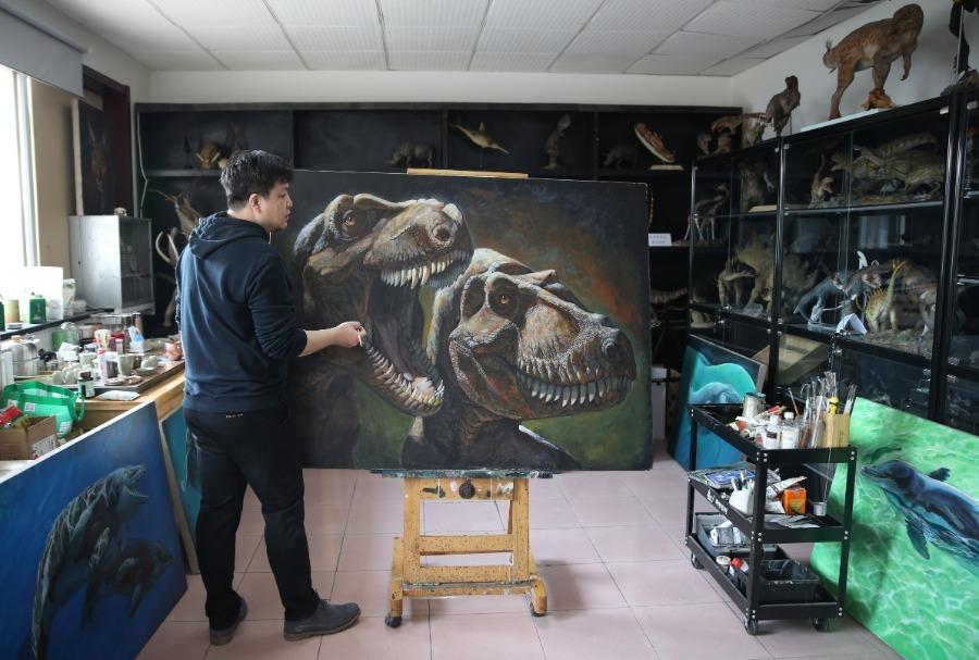 Zhao Chuang with his dinosaur-themed painting. (Photo/China Daily)