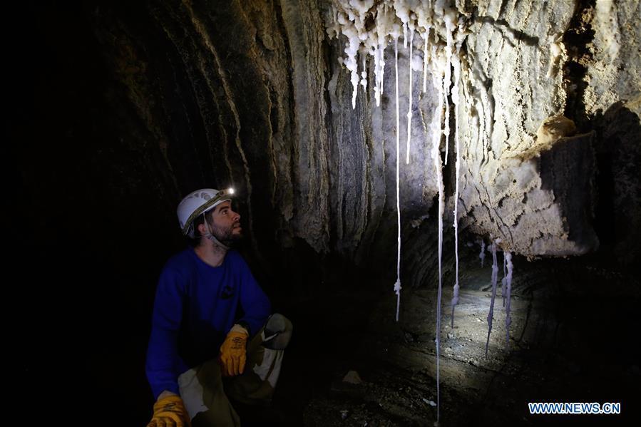 Boaz Langford, member of the Israel Cave Explorers Club and one of the heads of the Malham Cave Mapping Expedition, shows salt stalactites in the Malham cave near the Dead Sea in southeastern Israel on April 14, 2019. Israeli and European researchers have discovered the world\'s deepest salt cave, Malham Cave with a depth of at least 10 kilometers, near the Dead Sea, said a report issued Thursday by the Hebrew University of Jerusalem. The researchers re-measured the 7,000-year-old Malham Cave, near the Dead Sea in southeastern Israel, and found that it is much longer than 5.5 kilometers as previously thought. Thus, the Israeli cave bypasses Iran\'s Cave of the Three Nudes (3N) on Qeshm Island, which since 2006 has been considered the world\'s deepest salt cave with a depth of 6.58 kilometers. (Xinhua/Gil Cohen Magen)