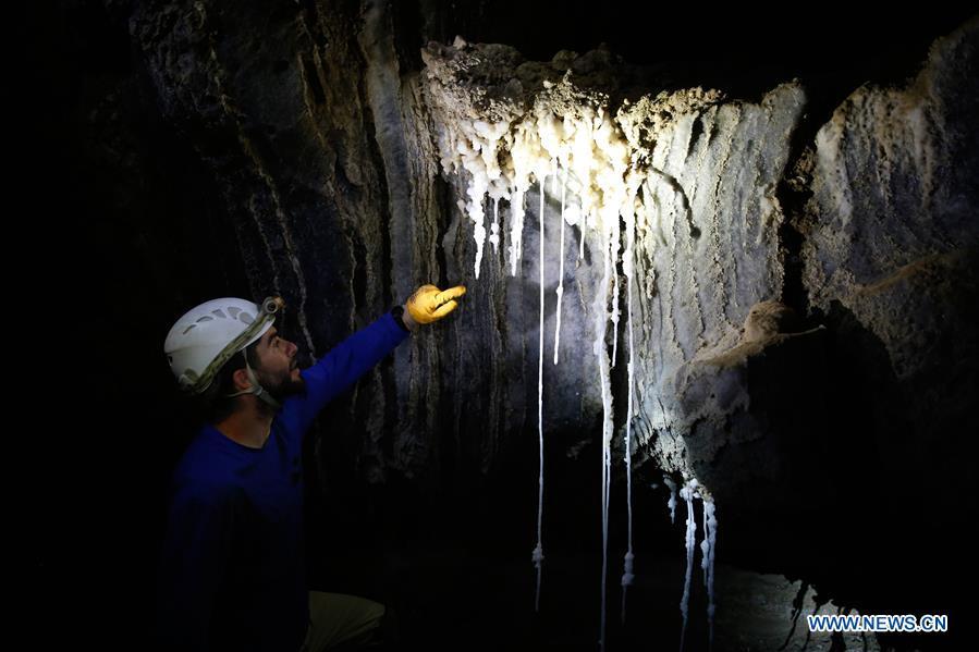 Boaz Langford, member of the Israel Cave Explorers Club and one of the heads of the Malham Cave Mapping Expedition, shows salt stalactites in the Malham cave near the Dead Sea in southeastern Israel on April 14, 2019. Israeli and European researchers have discovered the world\'s deepest salt cave, Malham Cave with a depth of at least 10 kilometers, near the Dead Sea, said a report issued Thursday by the Hebrew University of Jerusalem. The researchers re-measured the 7,000-year-old Malham Cave, near the Dead Sea in southeastern Israel, and found that it is much longer than 5.5 kilometers as previously thought. Thus, the Israeli cave bypasses Iran\'s Cave of the Three Nudes (3N) on Qeshm Island, which since 2006 has been considered the world\'s deepest salt cave with a depth of 6.58 kilometers. (Xinhua/Gil Cohen Magen)