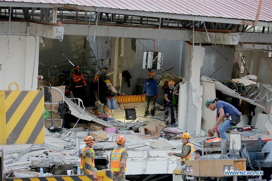 Rescuers search for victims at a collapsed building in Pampanga Province, the Philippines, April 23, 2019. The death toll from the 6.1-magnitude earthquake that struck the Philippines\' main Luzon Island rose to nine, local officials said on Tuesday. (Xinhua/Rouelle Umali)