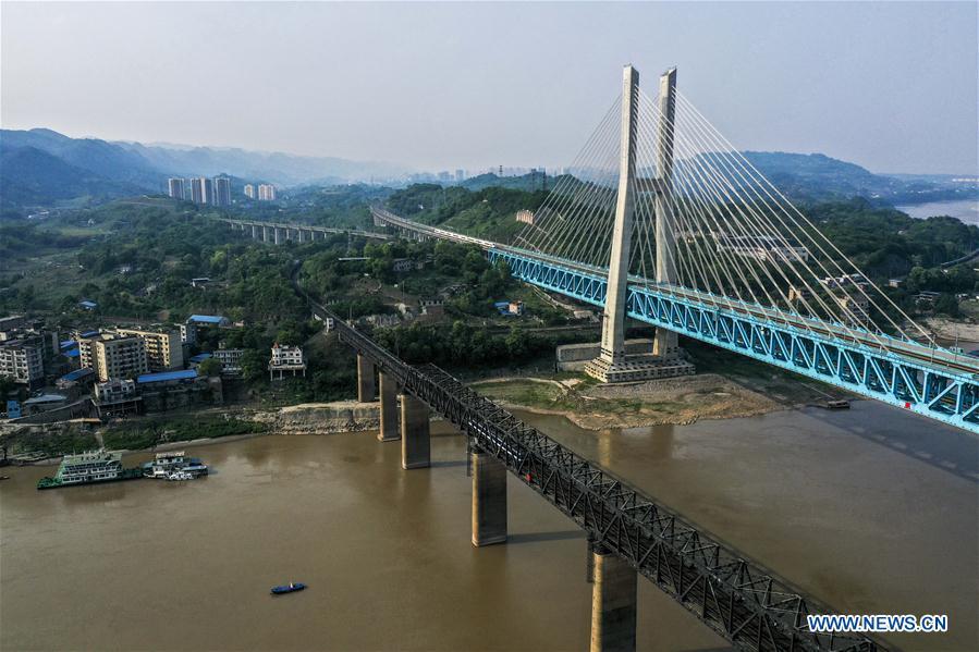 <?php echo strip_tags(addslashes(Aerial photo taken on April 23, 2019 shows the previous (L) and the new Baishatuo Yangtze River railway bridge in Jiangjin of southwest China's Chongqing Municipality. The previous Baishatuo Yangtze River railway bridge, completed in 1959, will stop service after April 24. All trains will run on the new double decker steel truss cable stay railway bridge after that day. The new bridge has 4 tracks on the upper deck for passenger trains with a designed speed of 200 kilometers per hour and 2 tracks on the lower deck for cargo trains with the designed speed of 120 kilometers per hour. (Xinhua/Liu Chan))) ?>