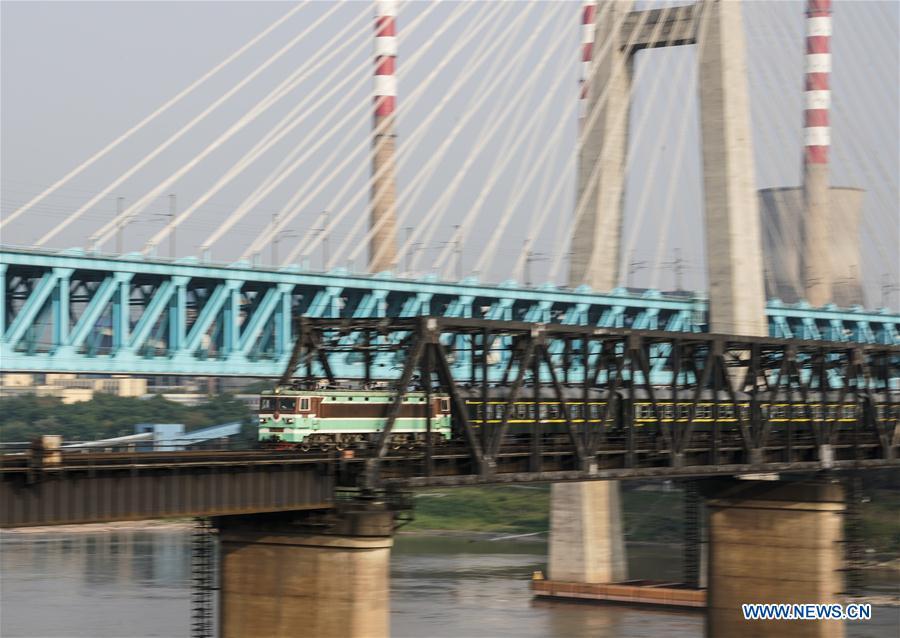 The last train runs on the previous Baishatuo Yangtze River railway bridge in Jiangjin of southwest China\'s Chongqing Municipality, April 23, 2019. The previous Baishatuo Yangtze River railway bridge, completed in 1959, will stop service after April 24. All trains will run on the new double decker steel truss cable stay railway bridge after that day. The new bridge has 4 tracks on the upper deck for passenger trains with a designed speed of 200 kilometers per hour and 2 tracks on the lower deck for cargo trains with the designed speed of 120 kilometers per hour. (Xinhua/Liu Chan)