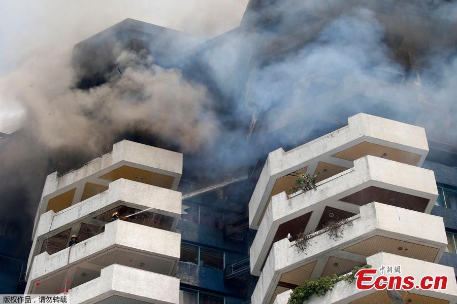 <?php echo strip_tags(addslashes(Fire burns in the top floors of a 21-story Pacific Coastal Plaza condominium in Manila, Philippines, April 29, 2019.  Officials say more than 100 firetrucks converged Monday to battle the blaze that hit the Pacific Coast Plaza condominium in the Paranaque city area of Manila, where one lane of a coastal road along Manila Bay was closed due to falling debris. A woman died in the accident. (Photo/Agencies))) ?>