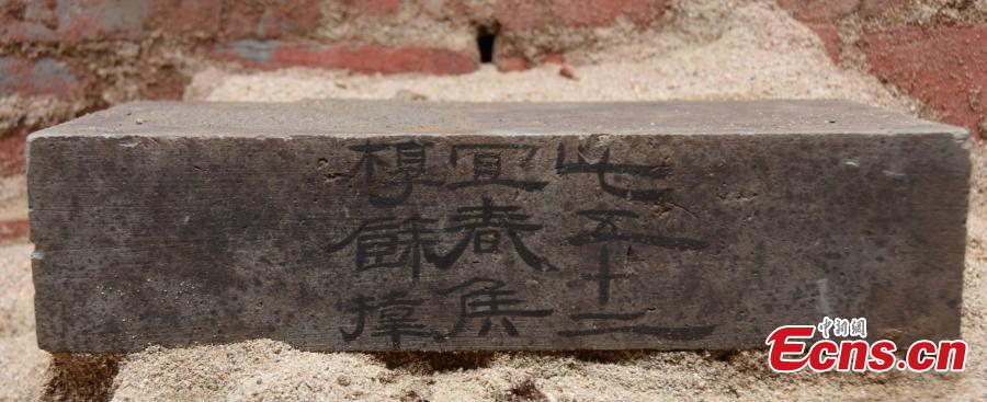 A brick displaying Chinese characters was found during the excavation of a tomb from the late Han Dynasty (206 BC?220 AD) in Xi\'an City, Northwest China\'s Shaanxi Province. Zhu Lianhua, the deputy director of the Xi\'an Cultural Relics and Archaeology Research Institute, said despite sand being filled around the tomb to protect it, raiders had struck at the site many times. (Photo provided by the Xi\'an Cultural Relics and Archaeology Research Institute)