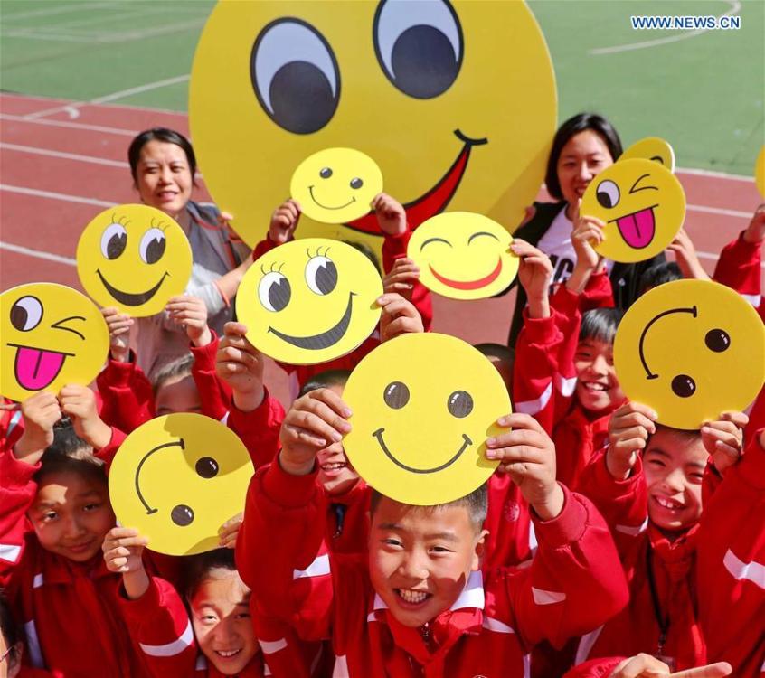 Pupils demonstrate smiley cards to greet the upcoming World Smile Day at a primary school in Qinhuangdao, north China\'s Hebei Province, May 7, 2019. World Smile Day is celebrated on May 8 every year. (Xinhua/Cao Jianxiong)
