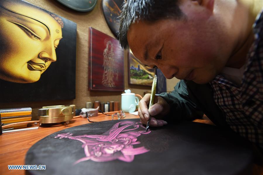 <?php echo strip_tags(addslashes(Shen Hongjie makes a woodcut at his workshop in Dunhuang, northwest China's Gansu Province, May 6, 2019. In 2004, Shen Hongjie was impressed by Dunhuang culture as he came here for sightseeing. He then left his hometown in central China's Hunan Province for Dunhuang. For 15 years, Shen Hongjie has been dedicated to promoting Dunhuang culture through woodcut. (Xinhua/Fan Peishen))) ?>