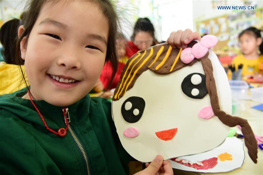 A kid demonstrates a handmade smiley card to greet the upcoming World Smile Day at a kindergarten in Zhenjiang, east China\'s Jiangsu Province, May 7, 2019. World Smile Day is celebrated on May 8 every year. (Xinhua/Shi Yucheng)