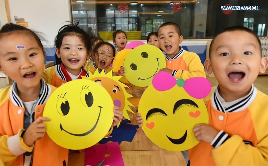 Kids demonstrate smiley cards to greet the upcoming World Smile Day at a kindergarten in Zigui County, central China\'s Hubei Province, May 7, 2019. World Smile Day is celebrated on May 8 every year. (Xinhua/Wang Huifu)
