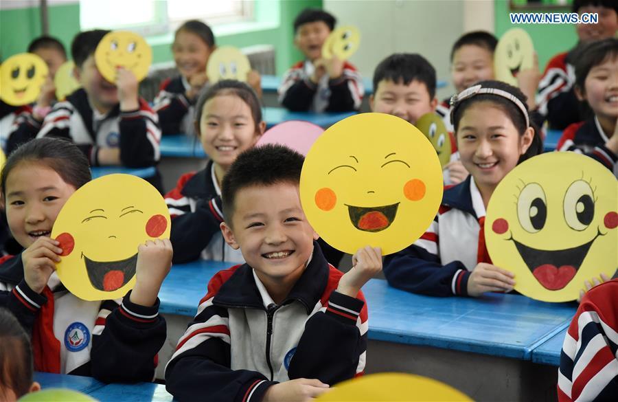 Pupils demonstrate smiley cards to greet the upcoming World Smile Day at a primary school in Handan, north China\'s Hebei Province, May 7, 2019. World Smile Day is celebrated on May 8 every year. (Xinhua/Hao Qunying)