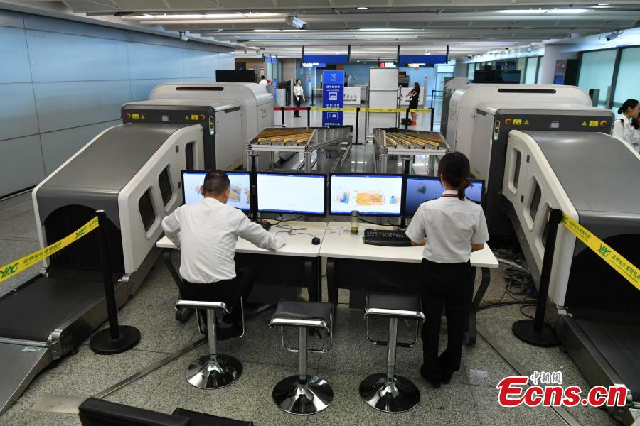 A Kunming Customs officer checks a passenger\'s luggage using a scanner at the Changshui International Airport in Kunming City, Yunnan Province, May 8, 2019. Kunming Customs showcased endangered species and wildlife products seized by staff at the airport. (Photo: China News Service/Ren Dong)