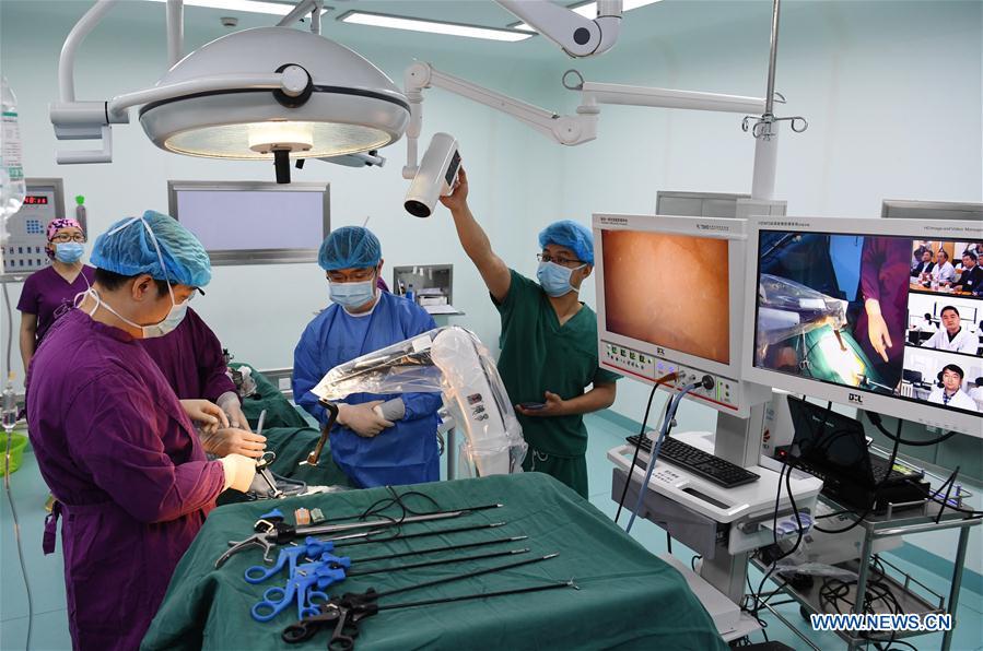 Medical staff of the Shitai County People\'s Hospital conduct an endoscopic surgery under the guidance from experts of the Second Hospital of Anhui Medical University (AMU) through a 5G-supported remote collaborative operating platform in Shitai, east China\'s Anhui Province, May 10, 2019. The first 5G network-supported remote collaborative operation was successfully conducted Friday at two hospitals in Anhui. Medical experts from the Second Hospital of AMU guided two endoscopic surgeries operated by another county hospital via 5G technology remotely and timely, during which the experts remote-adjusted the operating machines through voice. (Xinhua/Xu Minhao)