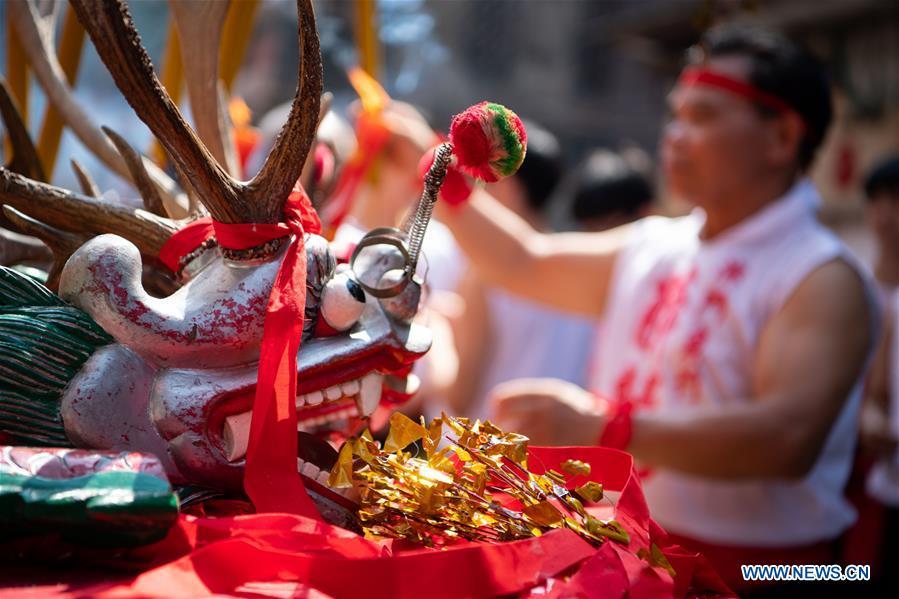 A drunk dragon dance performer burns incense before performing during the Drunken Dragon Festival in south China\'s Macao, May 12, 2019. Recognized as an item of China\'s national intangible cultural heritage, the Drunken Dragon Festival originates from a Macao legend of a Buddhist monk and a divine dragon who saved people from the plague during the Qing Dynasty. (Xinhua/Cheong Kam Ka)