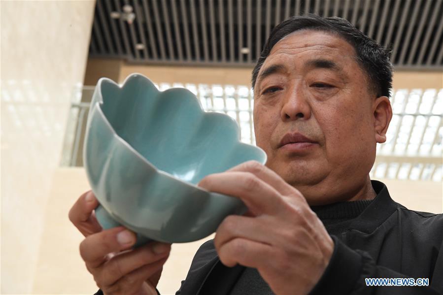 <?php echo strip_tags(addslashes(Wang Junzi checks a Ru porcelain work he made at a Ru porcelain museum in Baofeng County of central China's Henan Province, May 8, 2019. Ru porcelain, one of the five famous kinds of porcelains during the Song Dynasty (960-1279) in ancient China, is known for its azure color, light body, filmy grain and gentle textile. Wang Junzi, born in 1960, is a Ru porcelain firing craftsman in Qingliangsi Village of Baofeng County in central China's Henan, where the ancient official Ru porcelain kiln in Song Dynasty is located. In order to reproduce the beauty of 