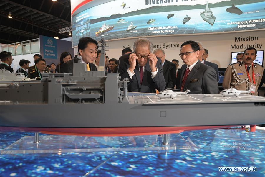 Singapore Defense Minister Ng Eng Hen (C, front) views exhibits at the 12th International Maritime Defense Exhibition and Conference (IMDEX Asia) in Singapore\'s Changi Exhibition Centre, May 14, 2019. Singapore Defense Minister Ng Eng Hen welcomed here Tuesday foreign navies attending the 12th International Maritime Defense Exhibition and Conference (IMDEX Asia) at its opening ceremony. A total of 23 warships from 15 countries sailed their way to IMDEX Asia at the Changi Naval Base, together with 26 chiefs of defense forces and navies, vice chiefs, directors-general of coast guards and senior naval officers. (Xinhua/Then Chih Wey)