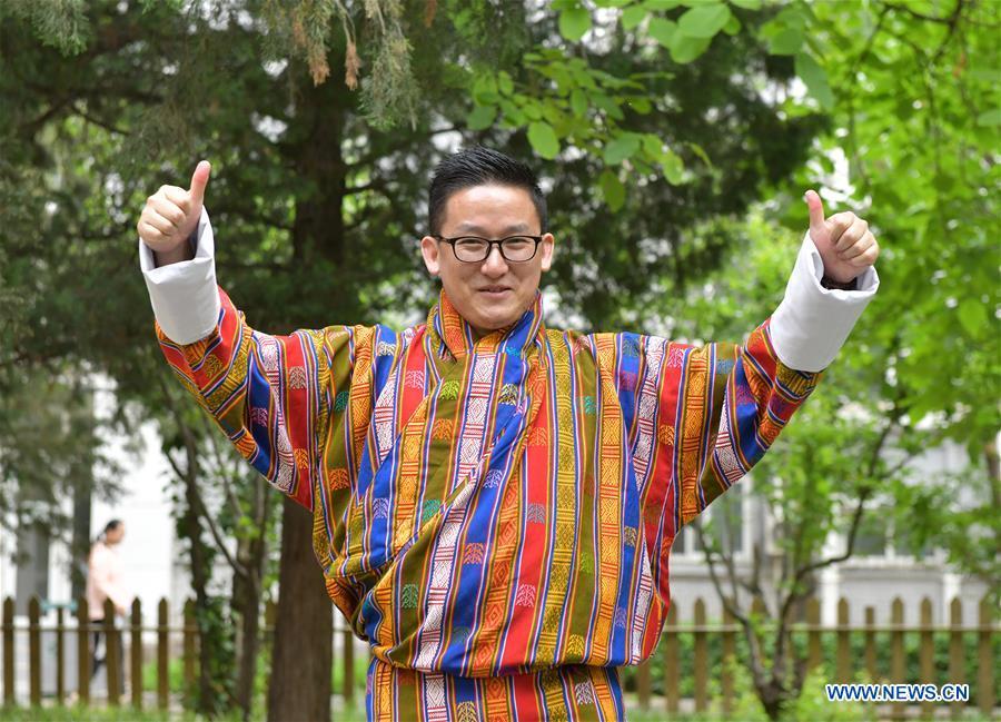 <?php echo strip_tags(addslashes(Sangay Tenzin displays traditional costumes made by his mother on the campus of the Beijing Language and Culture University in Beijing, capital of China, May 14, 2019. Sangay Tenzin, a Bhutanese student of Beijing Language and Culture University, is one of the photographers whose work was accepted by an exhibition themed 