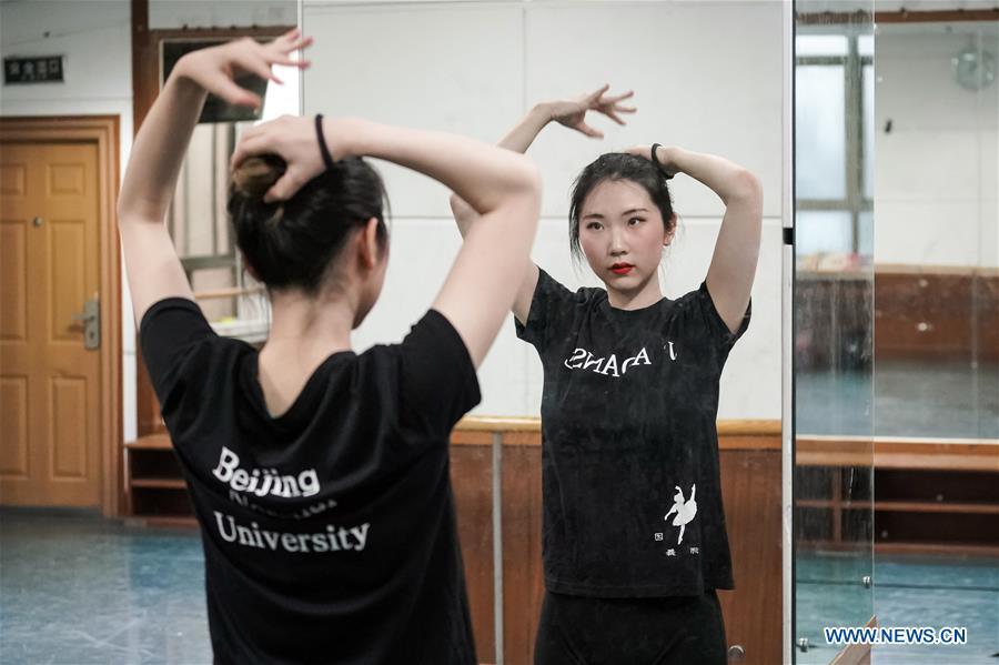 <?php echo strip_tags(addslashes(Feng Ganyu fixes her hair before dancing in a training room at Beijing Normal University in Beijing, capital of China, May 12, 2019. A photographic exhibition themed 